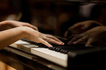 Fototapeta na wymiar Woman's hands on the keyboard of the piano closeup