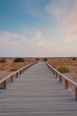 Wooden footbridge in the dunes, Algarve, Portugal, at sunset