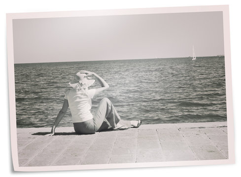 Faded holiday photo - woman on quay watches yacht. Retro filter.