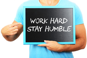 Man holding blackboard in hands and pointing the word WORK HARD