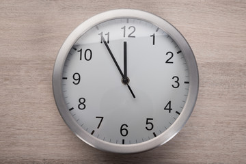 Clock showing five before noon