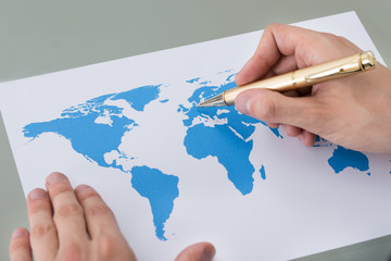 Businessman Marking Places On World Map