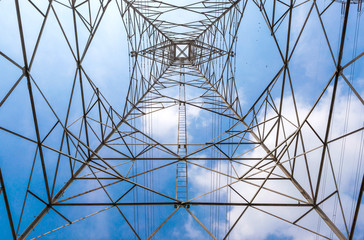 In the center of high voltage power pole and clear blue sky back