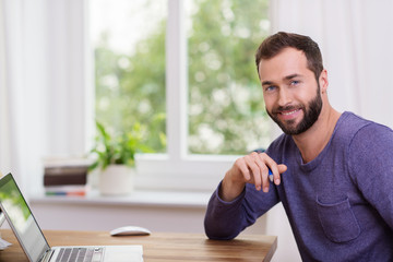 moderner typ arbietet zuhause am laptop