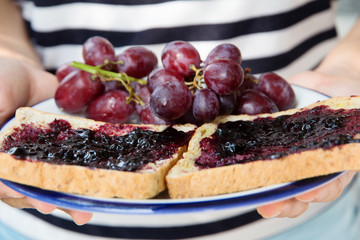 hand holding grape jelly sandwich