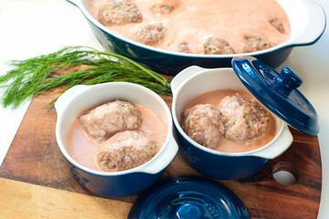 Raw meat balls with tomato sauce ready to cook.