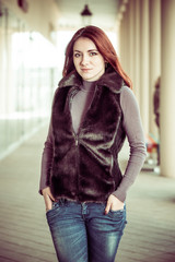 pretty redhead woman in waistcoat at city street