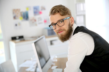 Young man with beard and eyeglasses in office