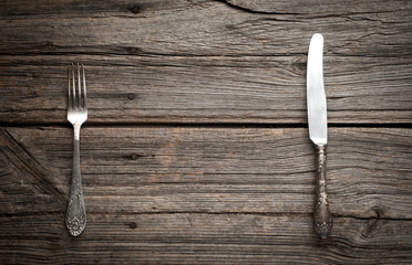 knife and fork on wooden background.