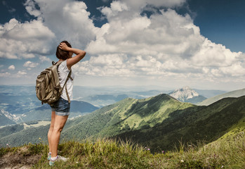 Fototapeta na wymiar Woman with backpack on the mountain hills