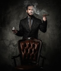 Handsome well-dressed with glass of beverage and cigar