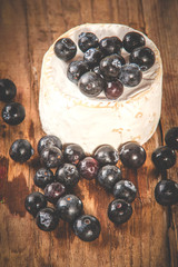 Smelly blue cheese on a wooden rustic table with blueberries
