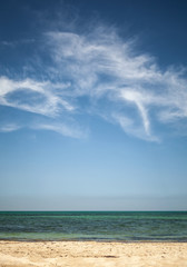 Beautiful cloudy sky over white sandy beach. Vertical photo back