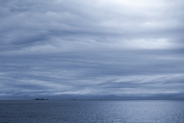 Naklejka na ściany i meble Dark blue stormy cloudy sky. Empty Norwegian Sea landscape backg