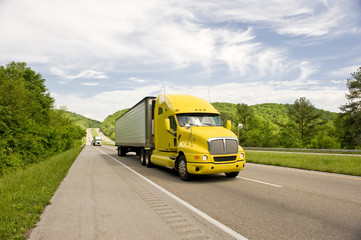 Fototapeta na wymiar Yellow Semi Truck Travels On Interstate In Springtime