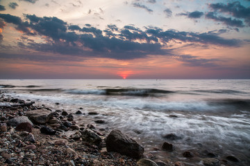 Baltic sea at beautiful sunrise on beach. big rocks in the water