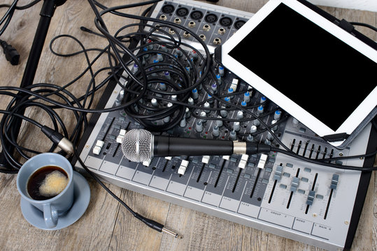 digital tablet placed on a audio mixer with a coffee