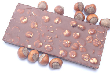 Chocolate bar with hazelnuts on white background