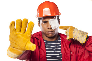 sad african worker with helmet and injured eye showing stop hand - obrazy, fototapety, plakaty