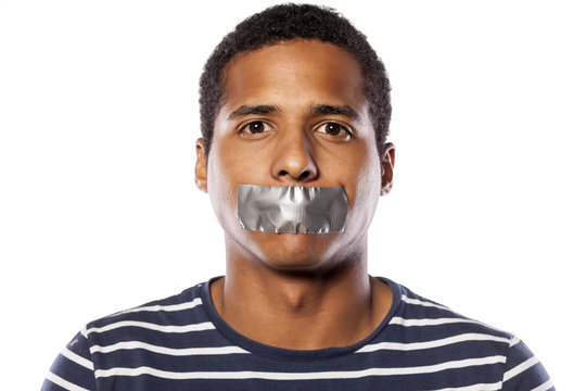 dark-skinned young man with adhesive tape over his mouth