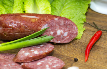 sausages on a wooden plate with vegetables in a restaurant