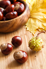 Sweet chestnuts in a bowl and on a wooden board