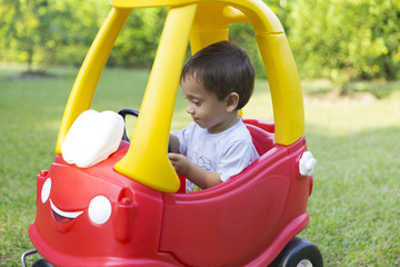 Fototapeta na wymiar Happy Little Boy Driving His Toy