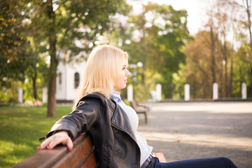 beautiful blond girl sitting on a bench