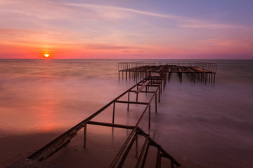 Fototapeta na wymiar Beautiful sunrise landscape with a pier on background. Long expo
