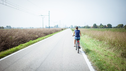 Obraz premium girl cycling on deserted road