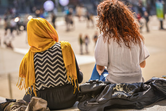 Two girls sitting and chatting outdoors
