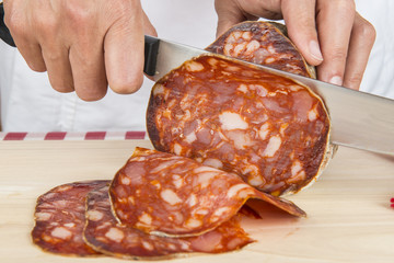 Carnicero cortando lonchas de morcón ibérico sobre la tabla