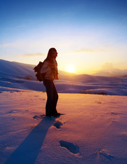 Fototapeta na wymiar Woman traveler hiking in winter mountains