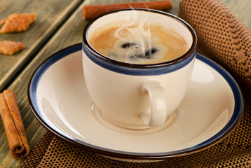 Hot Coffee and cinnamon on a  wooden table