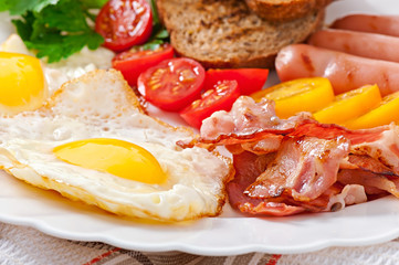 English breakfast - fried eggs, bacon, sausages and toasted 