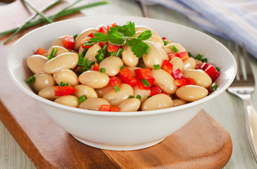 Salad with white beans on  wooden board.