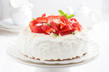 cake with whipped cream and strawberries on a stand