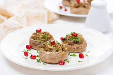 Stuffed mushrooms with herbs and pomegranate seeds on the plate