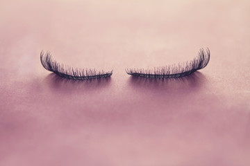Close up false eyelashes on pink background