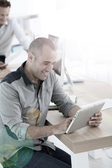 Young smiling man in training class using digital tablet