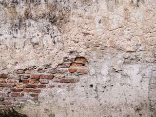 Old rustic wall with crack to show brick inside
