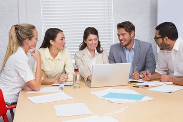 Casual business team having a meeting using laptop