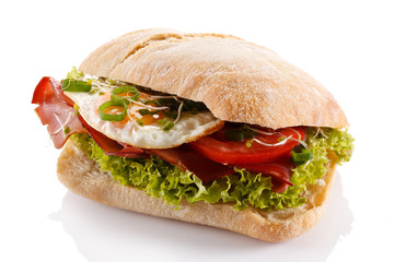 Breakfast - breadroll, fried egg, bacon and vegetables