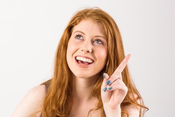 Pretty redhead pointing and looking up