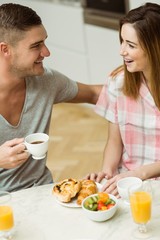 Obraz na płótnie Canvas Cute couple having breakfast together