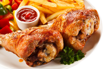 Grilled turkey legs with French fries and vegetables