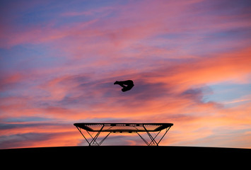 silhouette of man on trampoline in sunset - 71036293