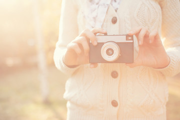Hipster girl holding a film camera outdoor