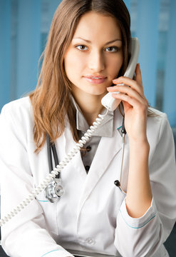 Young doctor on phone, at office