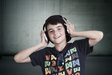 child with current clothing with headphones listening to music